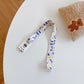 Kids beverage bottle lanyard strap, white with blue music-note style print