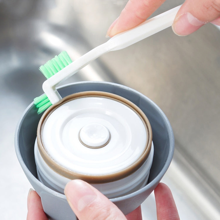 Crevice cleaning brush in use, scrubbing inside a bowl with foam pad and bristles