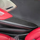 Close-up of carbon-fiber style inner armrest panel stickers on black armrest with red stitching