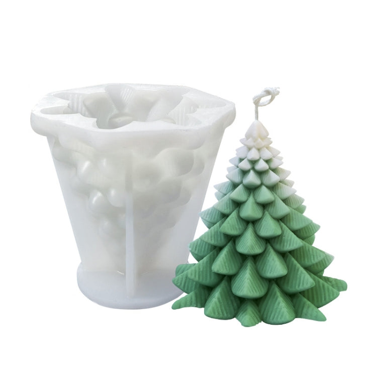 White silicone candle mold with green Christmas tree candle; layered rows and top ornament visible.