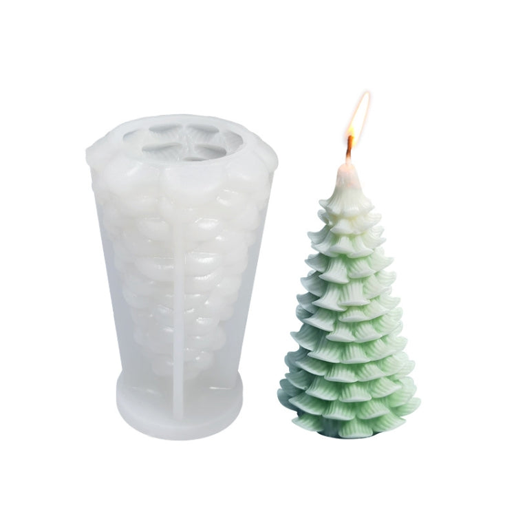 White silicone candle mold with white and green Christmas tree candle; flame wick visible.