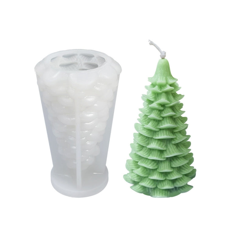 White silicone candle mold with light green Christmas tree candle; stacked branch layers visible.