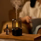 Black aroma diffuser with simulated candlelight and visible mist vapor