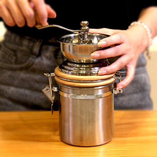 Stainless steel hand coffee grinder with wooden lid knob and crank handle