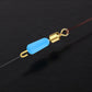Silicone eight-shaped ring connector attached to fishing line with gold cap and blue bead