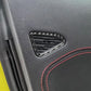 Close-up of installed black carbon-fiber door air vent trim sticker with red stitching edge