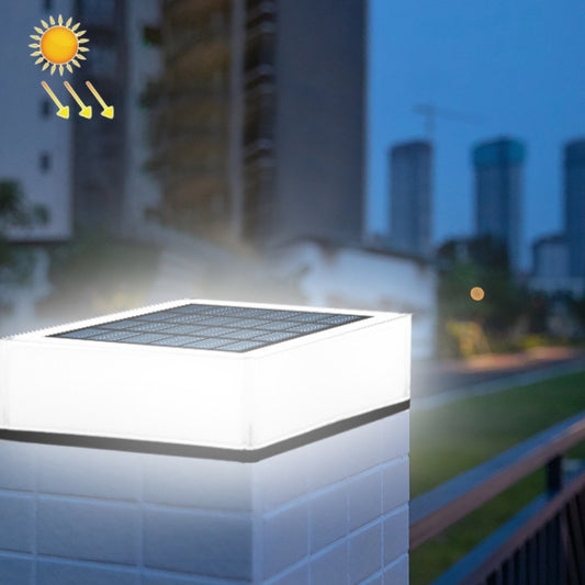 Outdoor solar deck light with square solar panel, white housing, warm glow