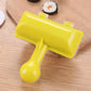 Yellow handheld sushi roll maker with clear ridged press and integrated handle paddle