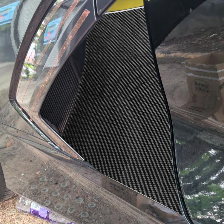 Black carbon-fiber exhaust port sticker panel installed on car side