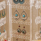 Clear earring rack close-up with layered hooks holding blue and green drop earrings