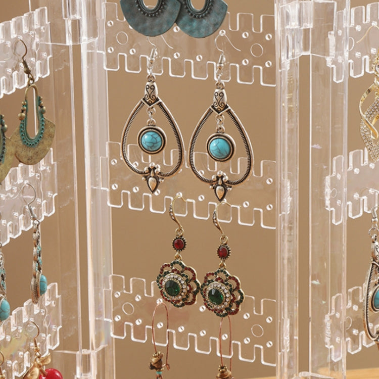 Clear earring rack close-up with layered hooks holding blue and green drop earrings