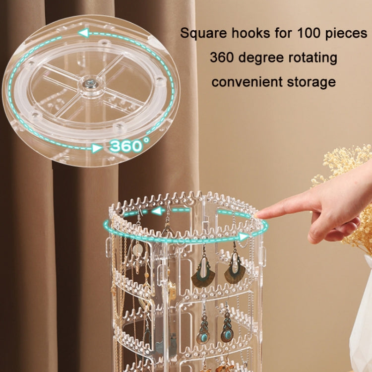 Clear 360° rotating earring organizer rack with square hook rows and a hand adding earrings