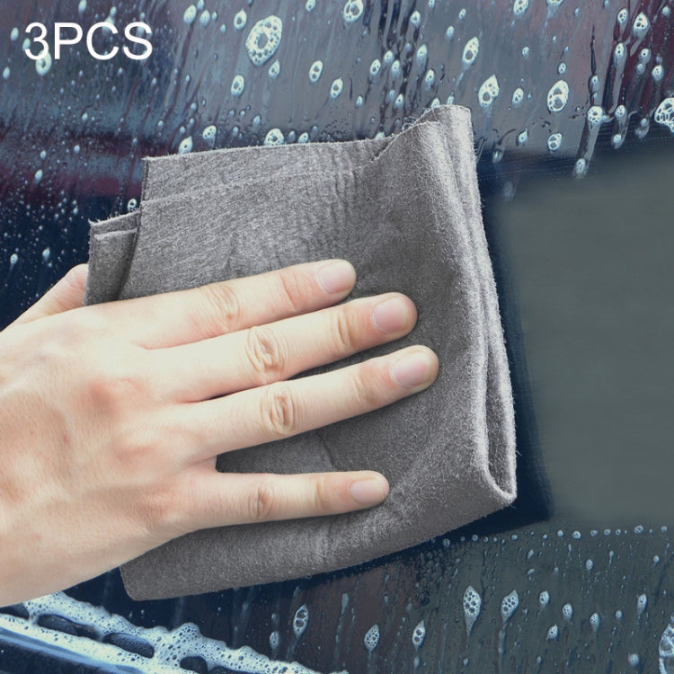 Grey microfiber cleaning cloth, folded square rags held in hand