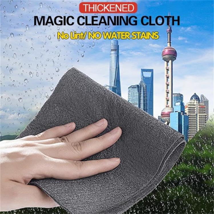 Grey thickened microfiber cleaning cloth, folded and held with water droplets