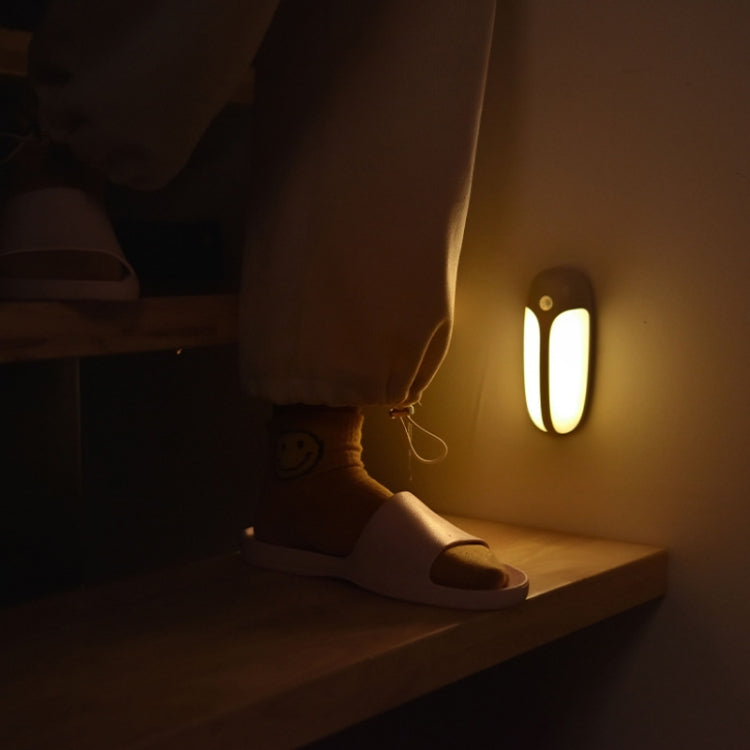 Wall-mounted LED body sensor light with a glowing oval LED panel