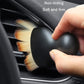Car vent dusting brush with rounded black grip and soft orange bristles
