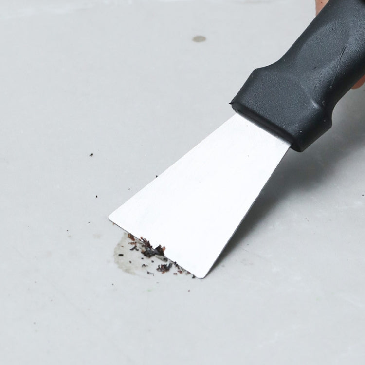 Straight-blade scraper tool removing debris from a flat surface