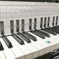 Piano practice chart laid over keys with staff lines and labeled finger positions