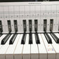 Keyboard practice chart on keys showing staff lines and labeled fingering blocks