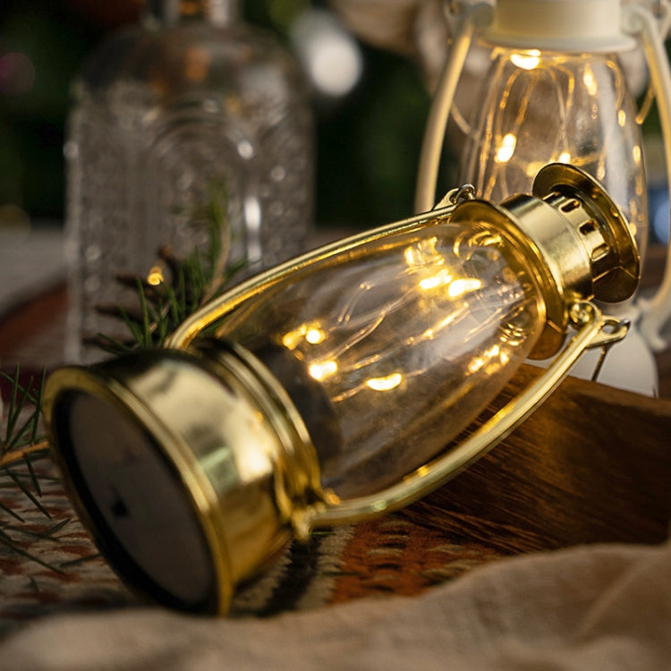 Gold retro lantern close-up with clear glass globe and metal loop handle