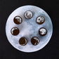Round moon phase wooden stamps on a tray: brown discs with white crater moon details