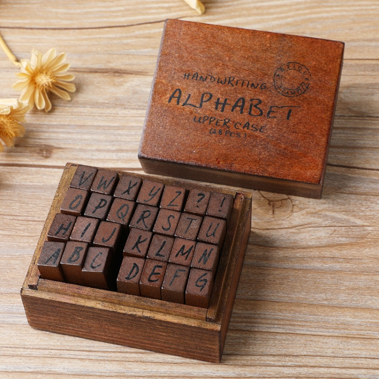 Wooden alphabet stamp set in open box with cursive-style uppercase letters and blocks