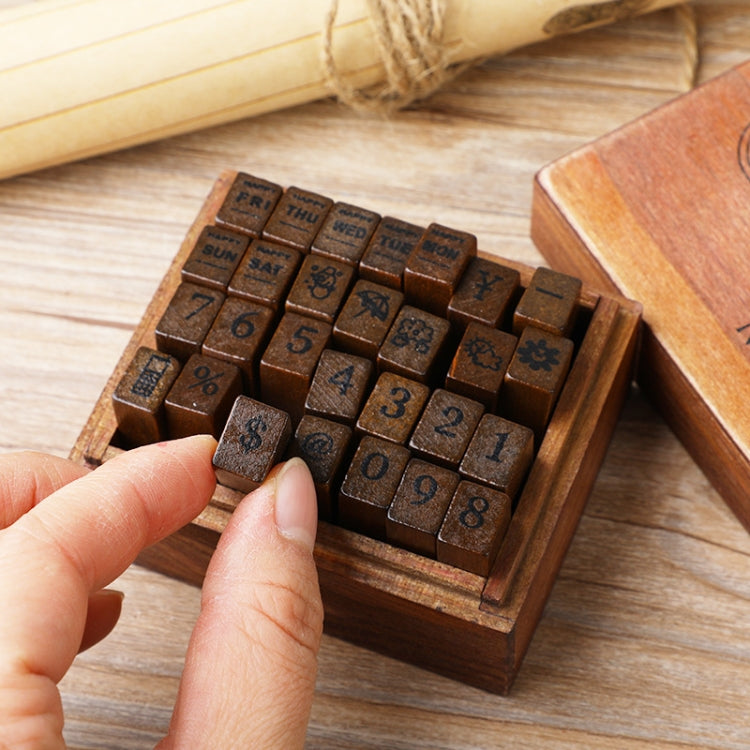Hand holding small wooden stamp blocks with number tiles and calendar-style text