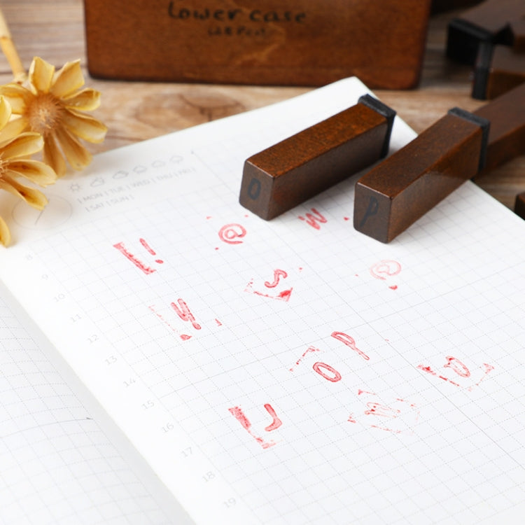 Wooden letter and number stamps creating red marks on grid paper