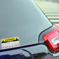 Warning car rules sticker on dark car panel near red tail light