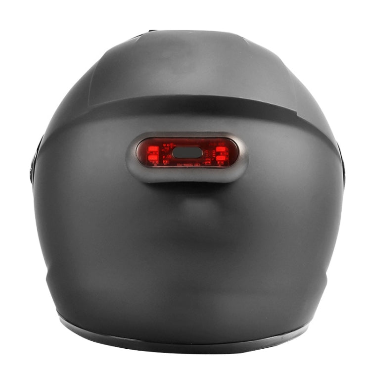 Motorbike helmet tail light on helmet rear, compact black unit with red LEDs.