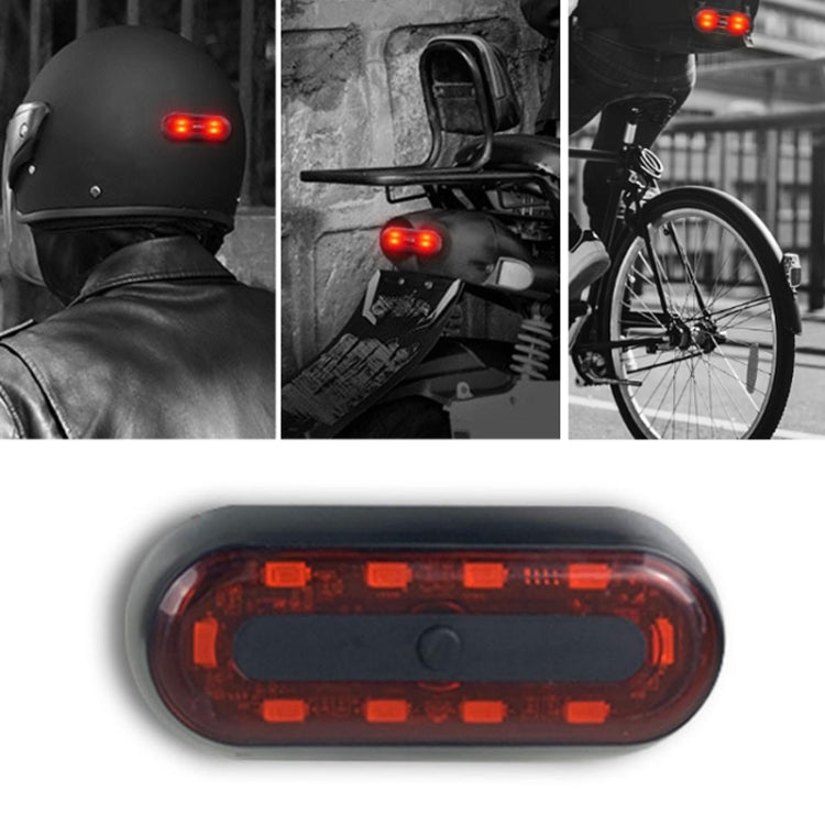 Motorbike helmet tail light close-up, red LED warning glow in black casing.