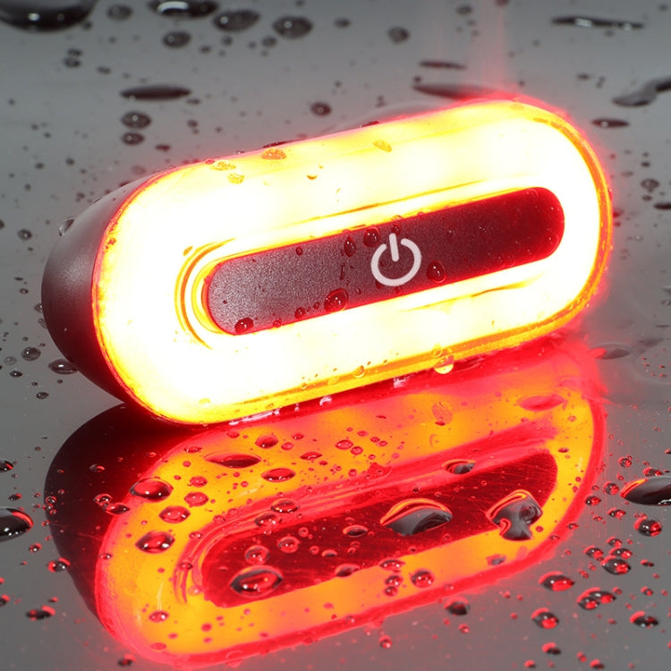 Helmet-mounted rechargeable tail light with red LED glow on dark helmet