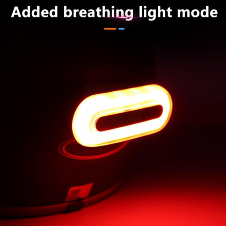 Rechargeable tail light in bright glowing mode, orange casing with illuminated red lens