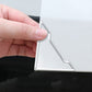 Silver corner bumper sticker being applied to a door edge panel by hand