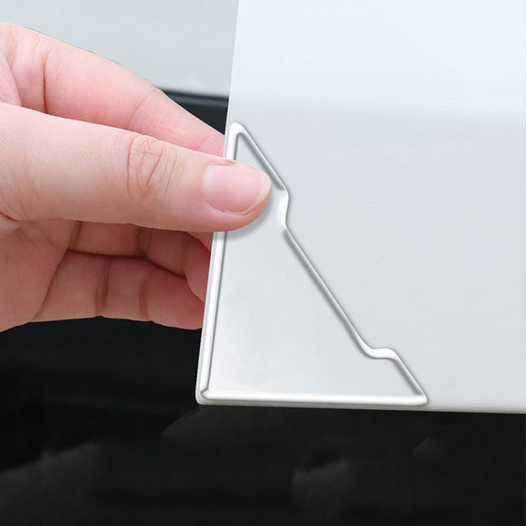 Silver corner bumper sticker being applied to a door edge panel by hand