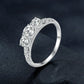 Sterling silver ring angled view with ornate filigree band and round moissanite-style stones