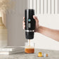 Portable espresso capsule coffee maker in hand, black body dispensing coffee into a cup