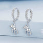 Silver-tone twist hoop earrings with dangling bear pendant and linked chain detail