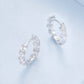 Silver zirconia hoop earrings with small flower clusters and hinged snap closure