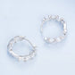 Silver hoop earrings with repeating zirconia bud flowers and sculpted metal details