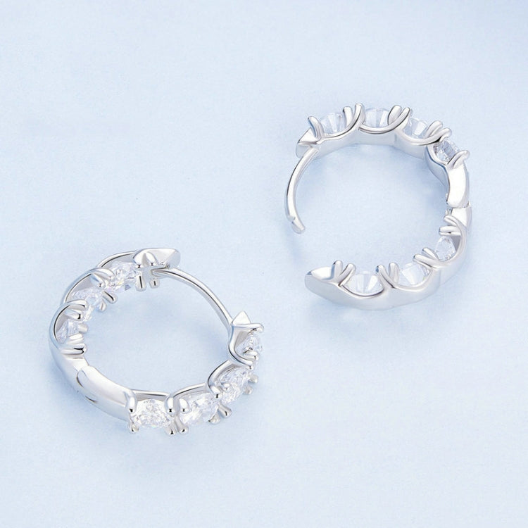 Silver hoop earrings with repeating zirconia bud flowers and sculpted metal details