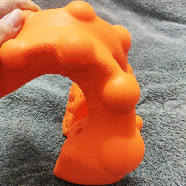 Orange acupressure massager close-up with raised dome nodes and ridged grips