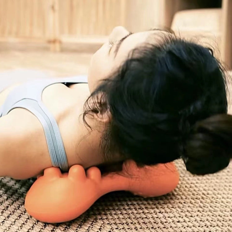 Orange acupressure massager resting on the body with raised nubs