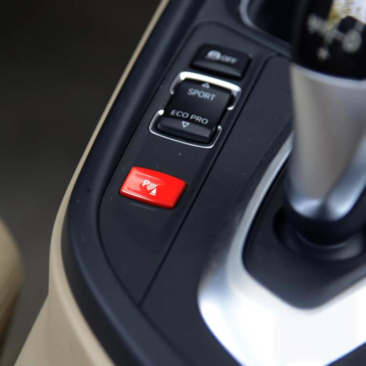 Red push-button with parking aid icon on center console switch panel