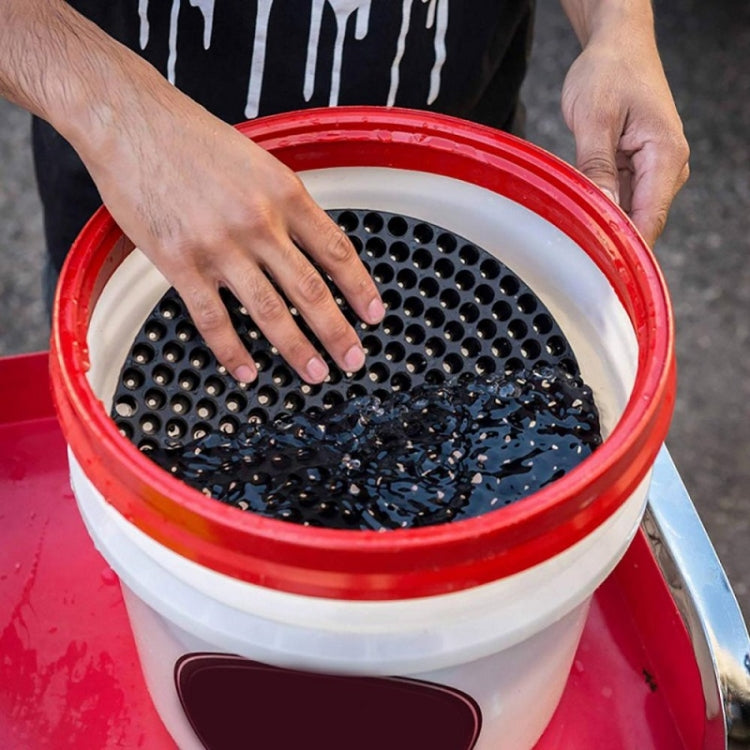 Car wash filter isolation net in red bucket, hands adjusting round perforated disc