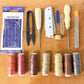 Leather repair sewing kit with needles, thread, snips, and measuring ruler on board
