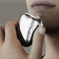 Electric mini shaver held in hand, rounded body with mesh head, silver