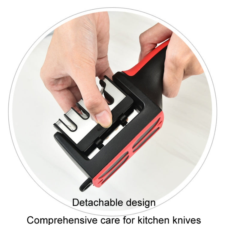 Red and black handheld knife sharpener being used with a knife blade