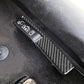 Carbon-fiber-look door lock switch trim strip with matching accents on car door.