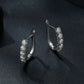 Silver U-shaped hoop earrings with scalloped settings and stacked clear stones